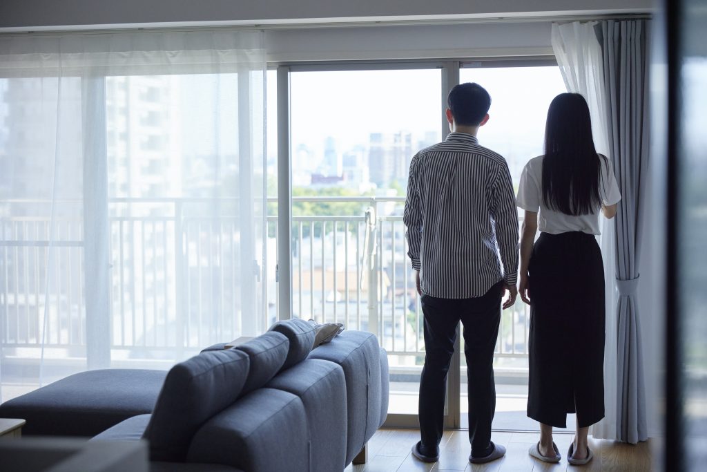 リノベーション後の室内から、夫婦が窓の外を見ている様子